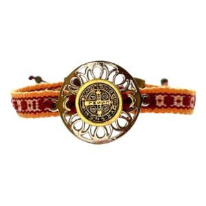 Pulsera con dije San Benito ajustable sobre cinta bordada oaxaqueña
